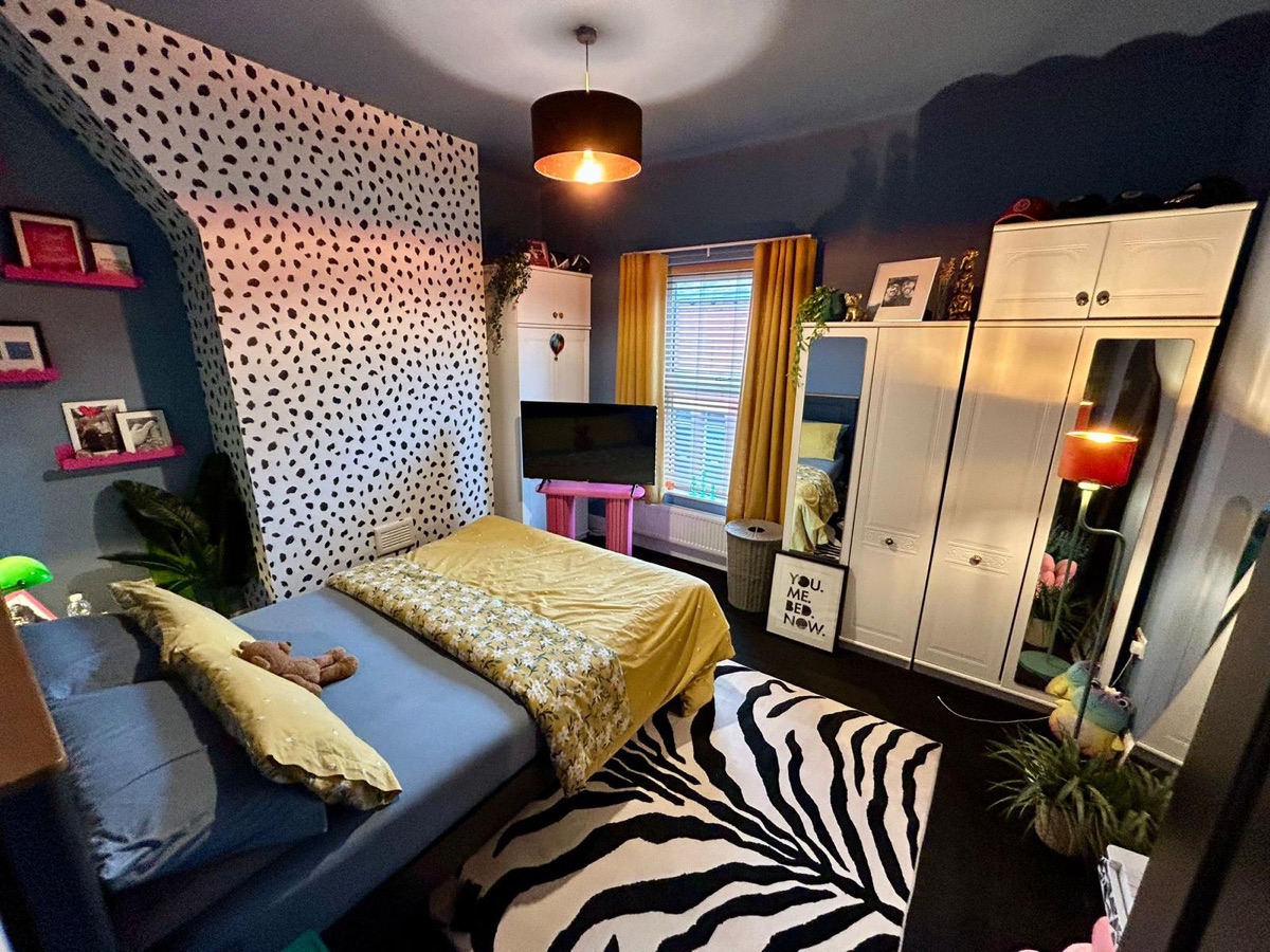 Bedroom with spotted feature wall and deep navy walls, decorated by English Rose